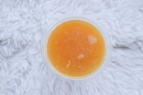Κάτοψη του φρέσκου φυσικού χυμού πορτοκαλιού σε ποτήρι σε λευκό φόντο. - Φωτογραφία, εικόνα