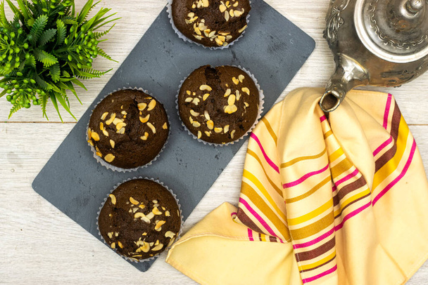 liitutaulu suklaa pähkinät muffinit, arabia teekannu puupöydälle - Valokuva, kuva