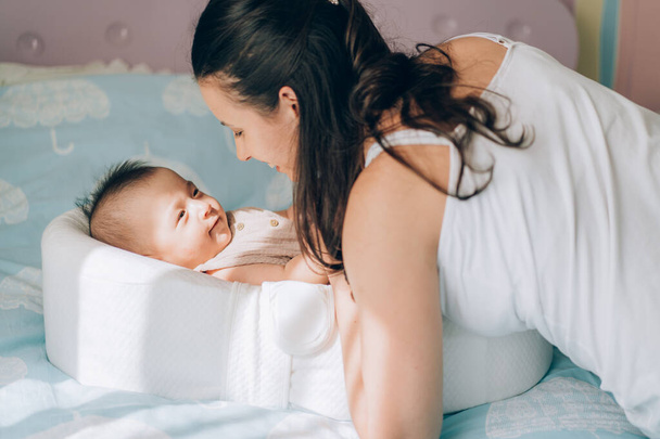 Junge Mutter umarmt ihr Mischlingskind. Adoption von Kindern und IVF zur In-vitro-Fertilisation . - Foto, Bild