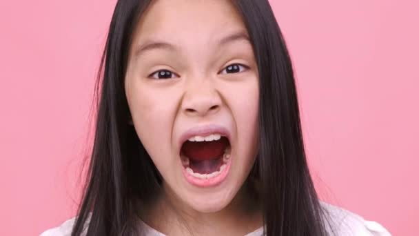 Cólera infantil. primer plano retrato de furioso poco asiático chica gritando a cámara, sintiendo enojado e insatisfecho - Imágenes, Vídeo