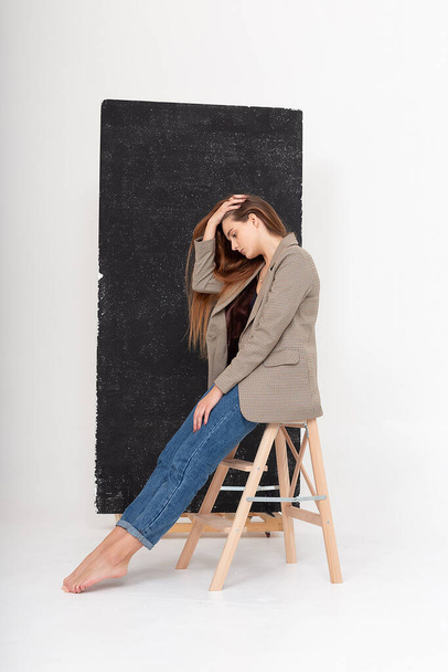 jovem mulher caucasiana atraente com cabelo castanho longo em jaqueta de terno no estúdio - Foto, Imagem