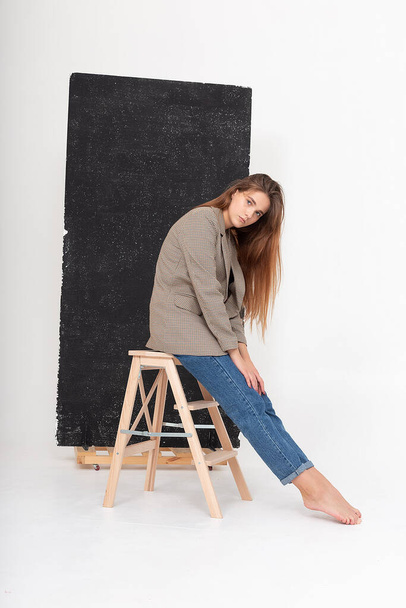 jovem mulher caucasiana atraente com cabelo castanho longo em jaqueta de terno no estúdio - Foto, Imagem