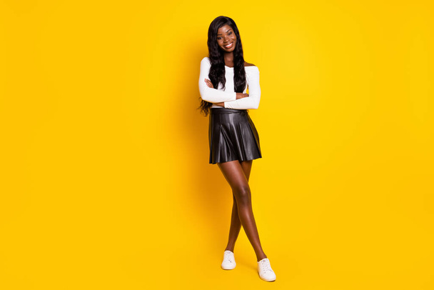 Full length body size photo of sexy black skinned brunette smiling with crossed hands isolated on bright yellow color background - Foto, imagen