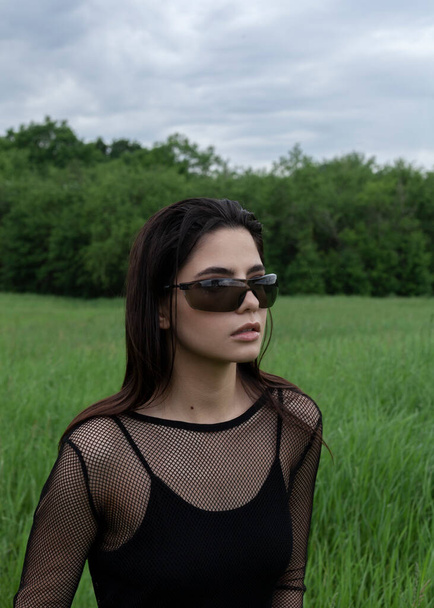 beautiful brunett girl in trandy black sunglasses in the forest  - Fotoğraf, Görsel