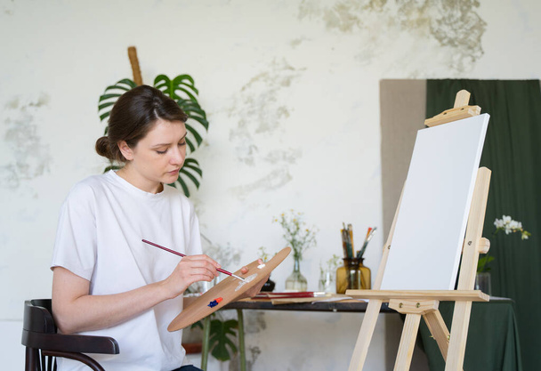Creative hobby. Portrait of a female artist in an art studio - Foto, Imagem