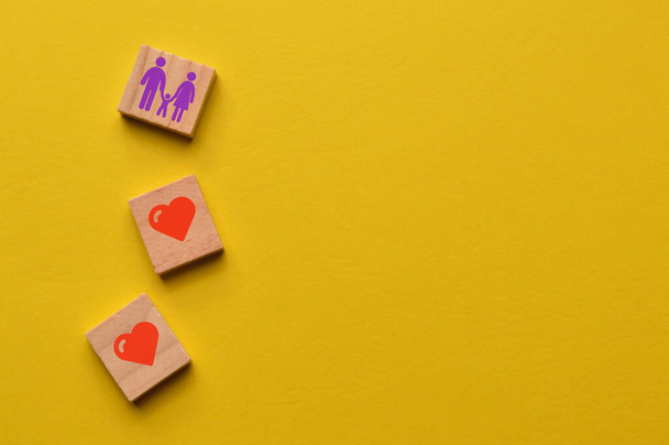 Дерев'яні блоки з іконками сімейної любові ізольовані на жовтому фоні
 - Фото, зображення