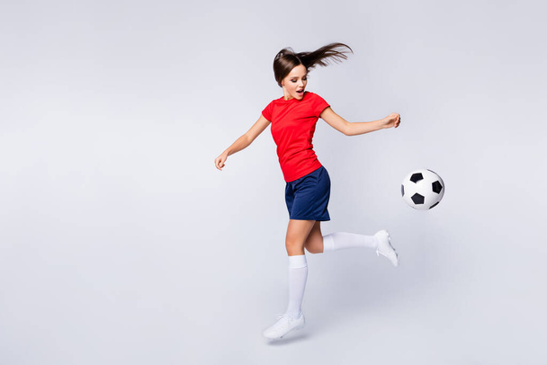 Full length profile photo of cool joy air fly player soccer team kick ball exercise training jump catch pass run wear football uniform t-shirt shorts cleats socks isolated white color background - Fotoğraf, Görsel