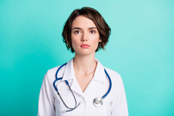 Photo of young woman serious confident doctor therapist clinic isolated over turquoise color background - Zdjęcie, obraz