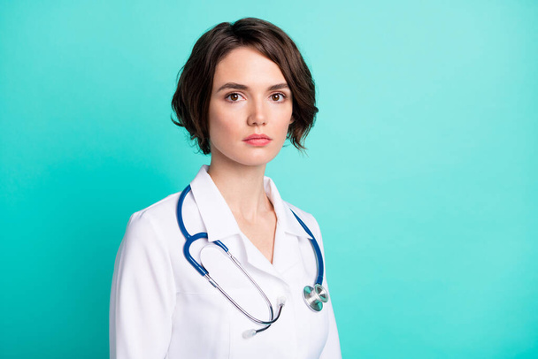 Photo de profil de jeune femme sérieuse confiante médecin pédiatre clinique isolé sur fond de couleur turquoise - Photo, image