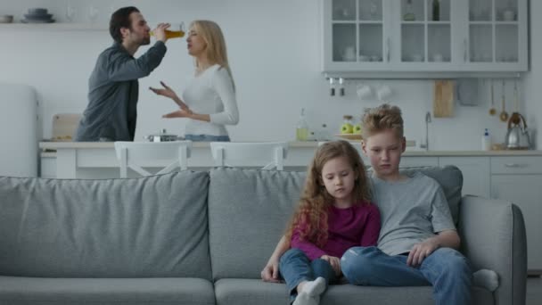 Familienprobleme wegen Alkohol. Betrunkener Ehemann streitet mit unglücklich gestresster Frau, zwei aufgebrachte Kinder sitzen auf Couch - Filmmaterial, Video