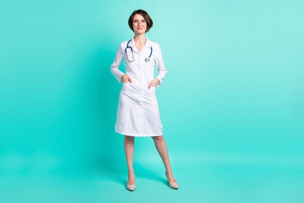 Full length body size photo of nurse smiling wearing white coat glasses isolated on vivid turquoise color background - Foto, imagen