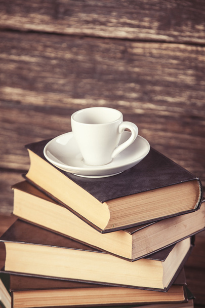 Books and cup of coffee on wooden background. - Фото, изображение