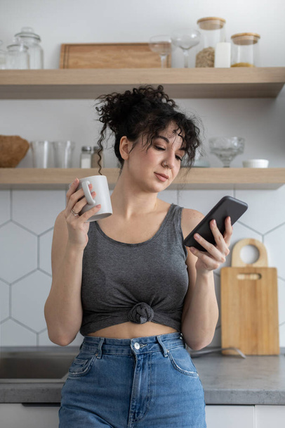 Joyful brunette woman chatting surfing internet use smartphone enjoying coffee break at cafe - Fotografie, Obrázek