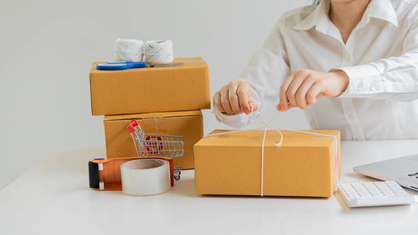 Start small business, business woman, successful SME entrepreneur. Work-at-home woman with laptop taking orders from customers with online parcel delivery. SME delivery concept and packaging - Photo, image