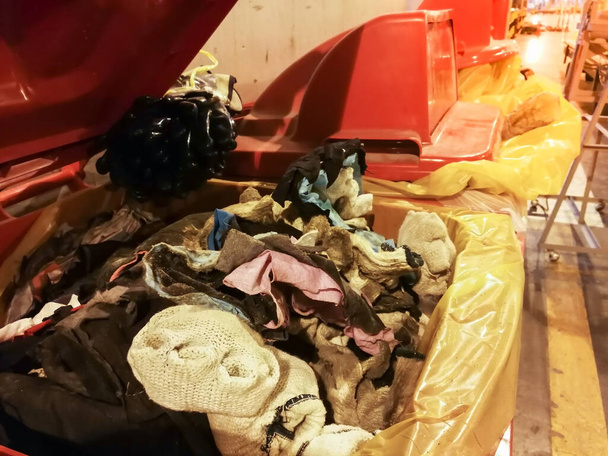 Gebrauchte Lappen und Handschuh Baumwolle mit Öl kontaminiert in roten Mülleimer in der Fabrik sortiert, Volle rote Abfallbehälter - Foto, Bild