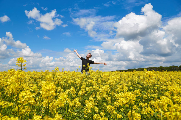 Chico feliz disfrutando de la vida sin alergia al polen en un campo de colza. - Foto, Imagen