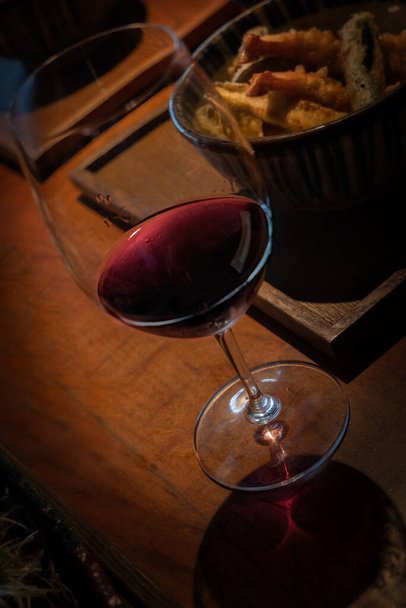 Egy pohár bor tengeri herkentyűkkel párosítva, egy asztalon ülve Roppongiban, Tokió külvárosában, Japánban.. - Fotó, kép