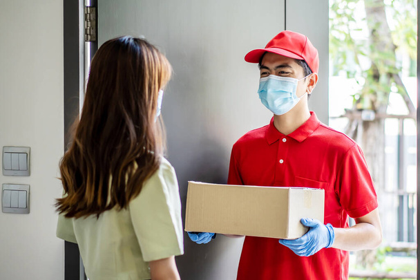 Чоловік доставки в червоній формі тримає коробки посилок для жінок клієнт концепція кур'єрської служби
 - Фото, зображення
