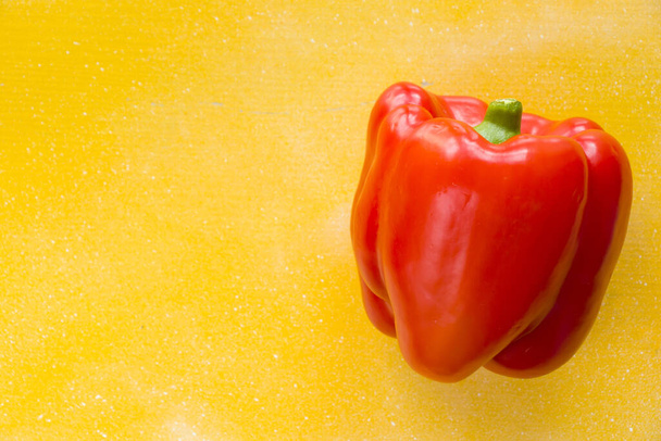 A top view of one red bell pepper on a yellow background - Valokuva, kuva