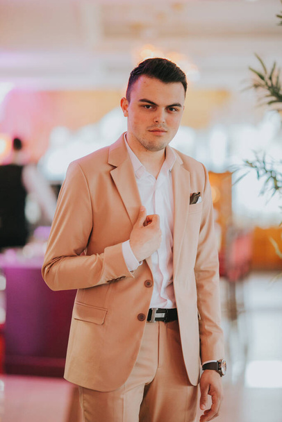 A vertical shot of a young handsome Caucasian male wearing a nice elegant suit - Фото, изображение