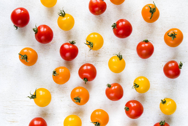 A top view of colorful cherry tomatoes on a white background - Valokuva, kuva