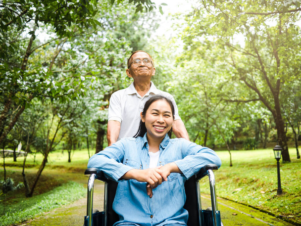 Šťastný senior muž na invalidním vozíku těší přírodu v parku. - Fotografie, Obrázek
