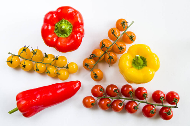 A top view of ripe bell peppers and cherry tomatoes isolated on white background - Fotoğraf, Görsel