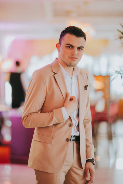 A caucasian young businessman in a suit standing in the restaurant - Fotó, kép