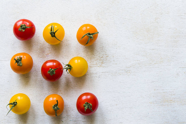 A top view of colorful cherry tomatoes on a white background - Foto, afbeelding