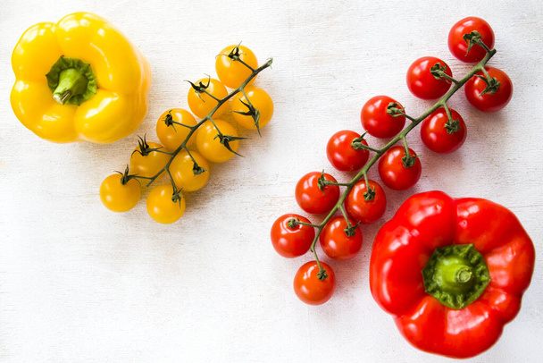 A top view of yellow and red color bell pepper with cherry tomatoes on a table - Foto, Imagem