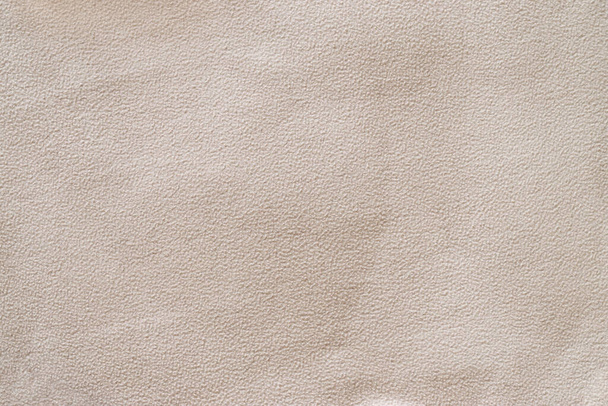 Abstracte textuur van beige badstof flanellen weefsel met pellets en klontjes close-up, achtergrond - Foto, afbeelding