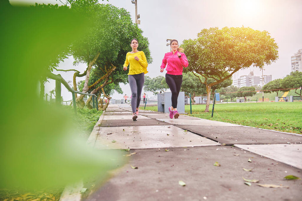 Femmes multiethniques jogging dans la rue, jogging dans la ville au crépuscule - Photo, image