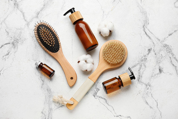 Composition with hair brush and cosmetics on light background - Photo, Image