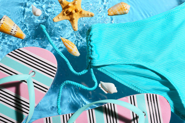 Zomer samenstelling met strand accessoires op kleur achtergrond met waterdruppels, close-up - Foto, afbeelding