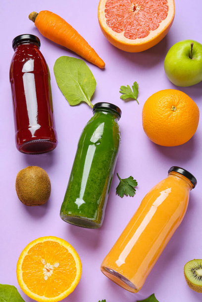 Bottles of healthy smoothie and ingredients on color background - Foto, afbeelding