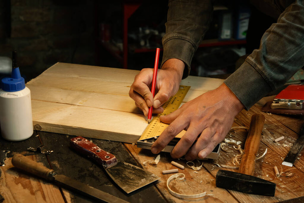 Tischler messen und markieren Holz mit Geschwindigkeitsmessgerät in Werkstatt - Foto, Bild