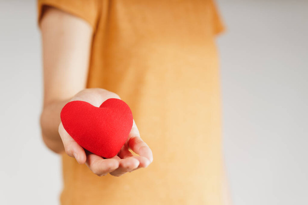  Frau mit rotem Herzen, Liebe, Krankenversicherung, Spende, glücklicher Freiwilliger für wohltätige Zwecke, Welttag für psychische Gesundheit, Weltherztag, Valentinstag - Foto, Bild