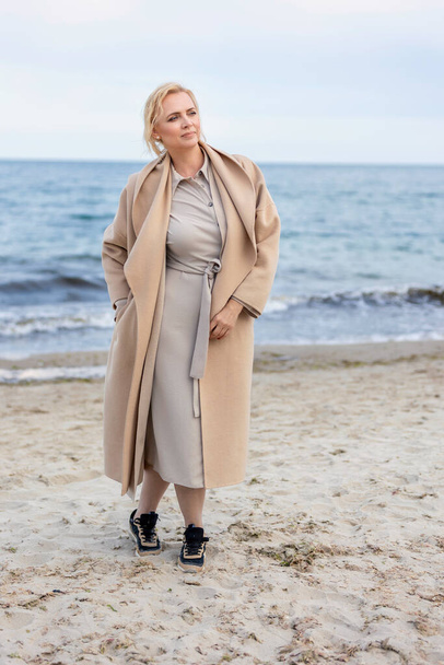 Woman in coat by the sea - Photo, image