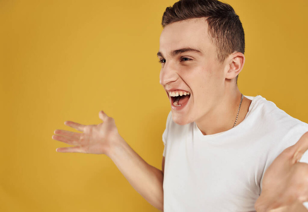 Cheerful man gesturing with his hands emotions joy yellow background - Foto, afbeelding
