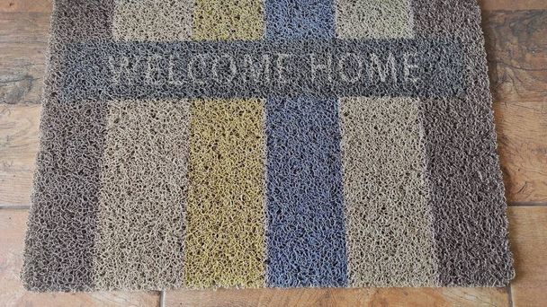 Foto de una alfombra de pie en frente de la casa que dice bienvenida - Foto, imagen