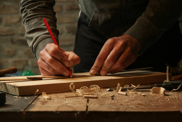 Ξυλουργός μέτρηση και σήμανση ξύλου στο εργαστήριο - Φωτογραφία, εικόνα