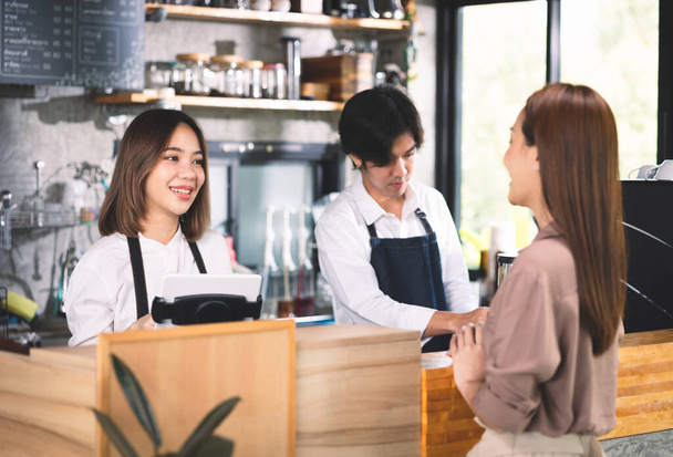A customer orders a hot latte to the barista. Asian Staff coffee shop cafe making hot coffee and serve to customer. Small business sme concept. - Photo, Image