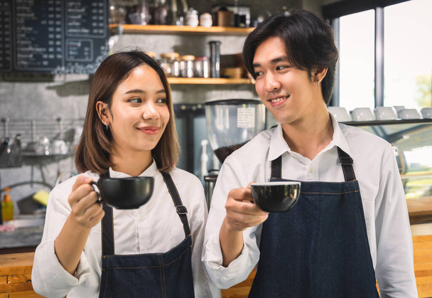 Dwie azjatyckie kelnerki robią filiżankę gorącej kawy latte w kawiarni. Barista pracuje z ekspresem do kawy w sklepie. - Zdjęcie, obraz