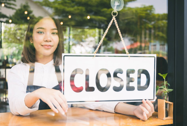 Zamknięta kawiarnia Młoda kobieta obaliła wytwórnię, by zamknąć swój biznes z powodu straty w sprzedaży kawy. - Zdjęcie, obraz