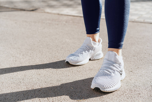Feet of a woman dressed in sportswear and sneakers for running - Fotoğraf, Görsel