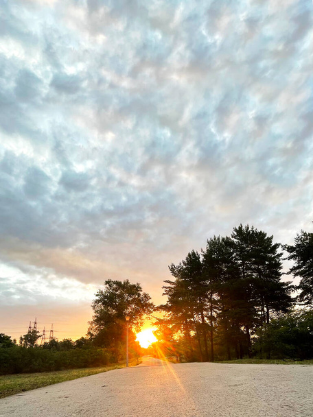 A nyári reggel a napfelkeltével elolvad a parkban. Sétálni a parkban sebezhető reggel. Gyönyörű nyári felhők. - Fotó, kép