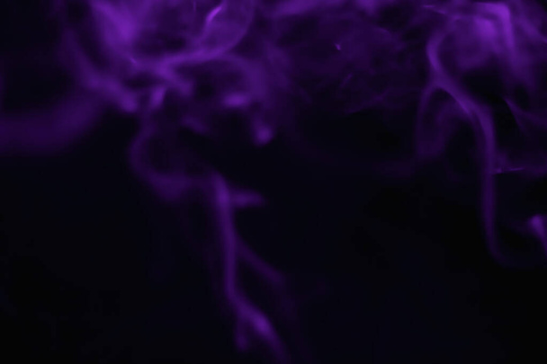 Purple smoke blurred on a black background - Фото, изображение