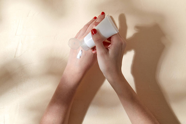 female hands applying moisturizer to skin - 写真・画像
