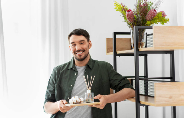 man placing aroma reed diffuser to shelf home - Fotó, kép