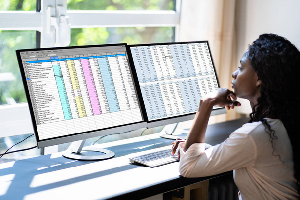 Analyste de données femme africaine en utilisant une feuille de calcul sur ordinateur - Photo, image